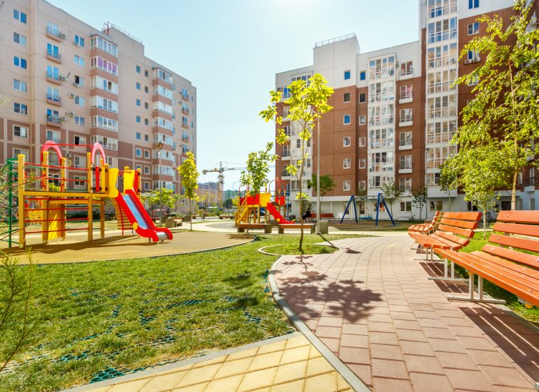An investment in an apartment complex that includes a playground with benches and swings.