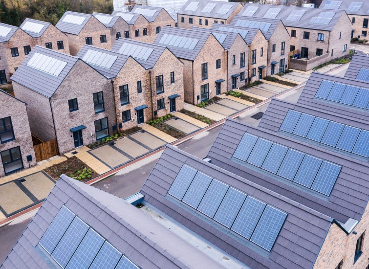 A line of housing with solar panels on their rooftops.
