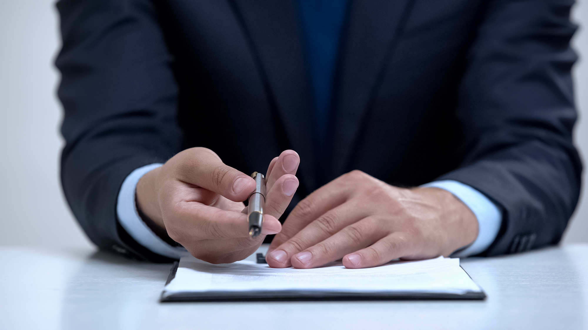 Lawyer hands holding out pen to sign business contract, sales agreement closeup